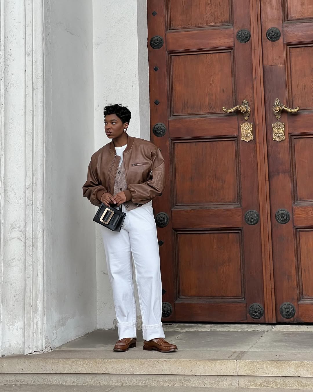 Grace in brown leather jacket and white jeans