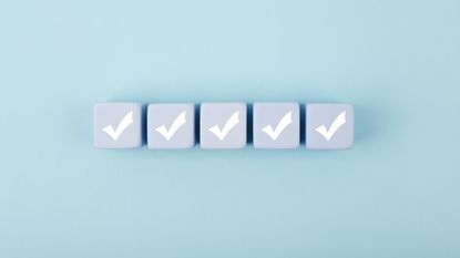 Five white checkmarks on white cubes against bright pastel blue background.