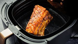 crispy pork frying in the base of an air fryer