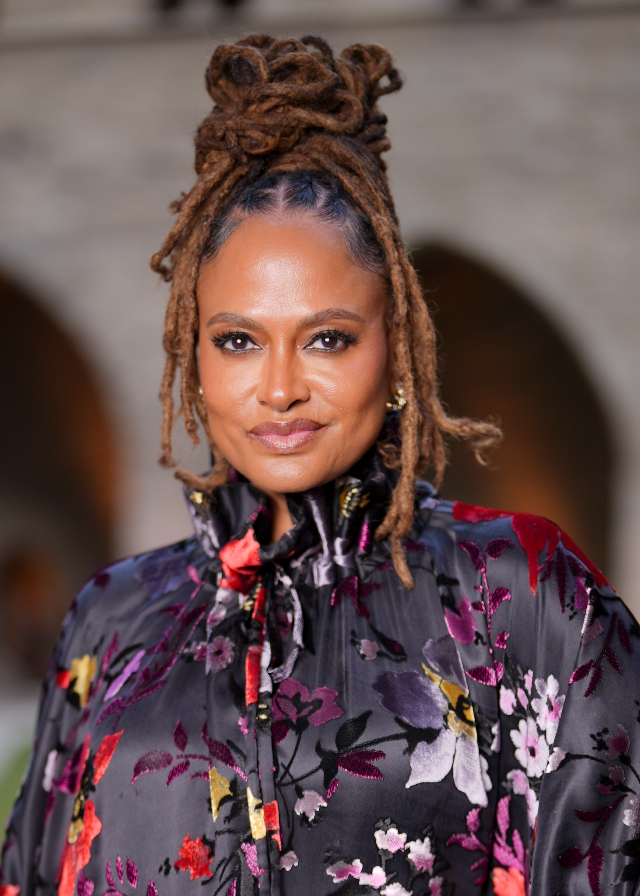 a black woman with caramel brown locs pulled into a high bun