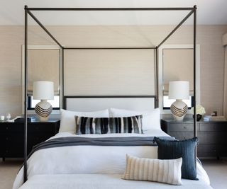 bedroom with modern four poster and gray side tables