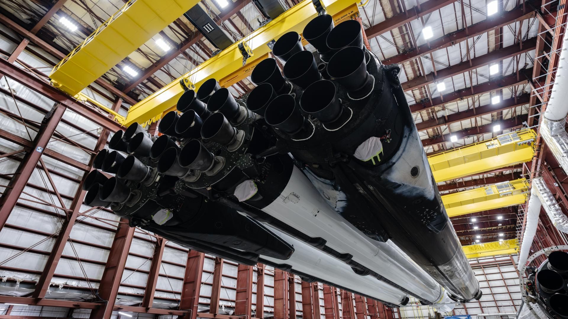 A photo of the Falcon Heavy rocket boosters hanging in a warehouse