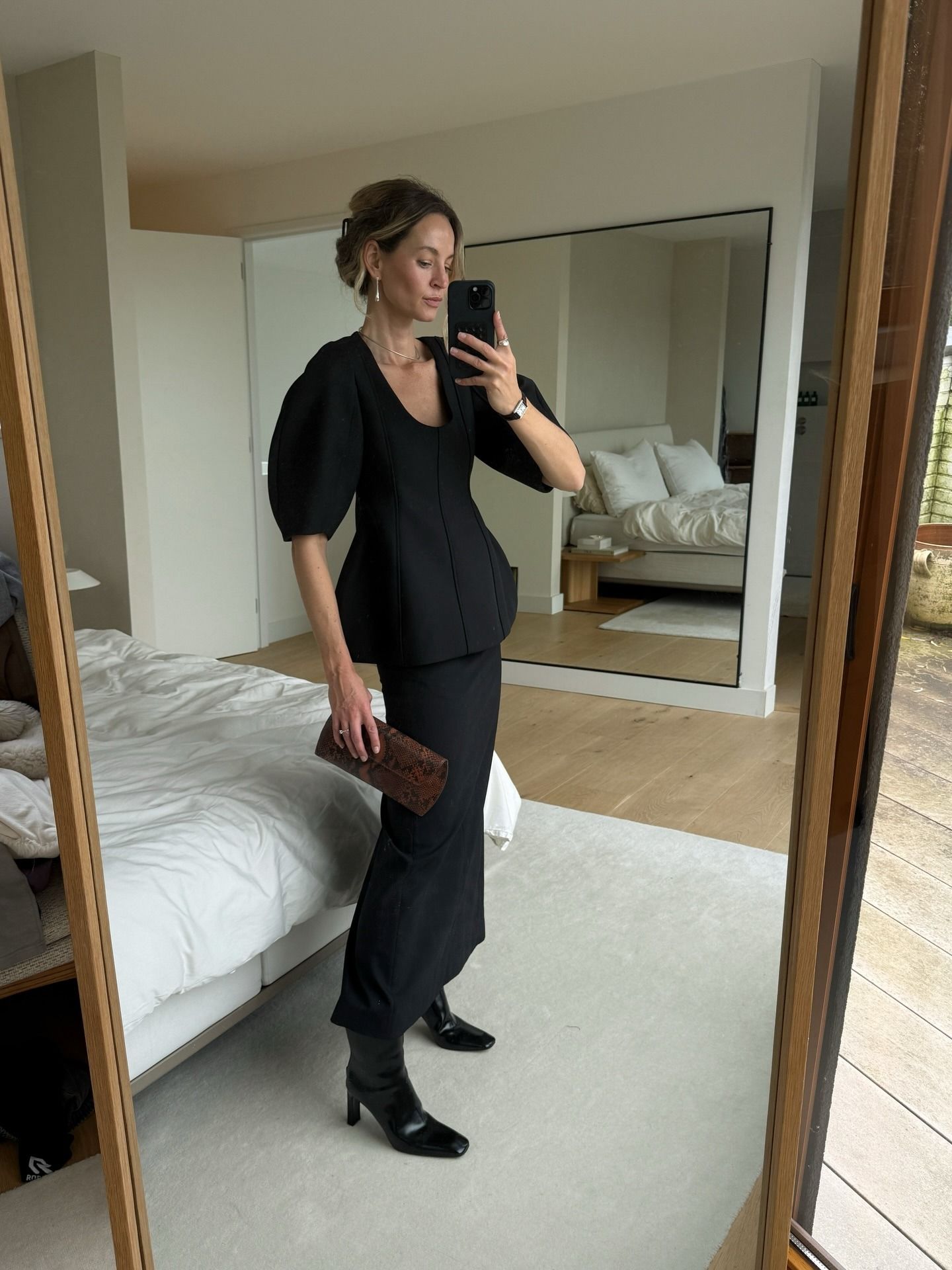 @anoukyve wearing a skirt outfit idea for 2026, including a sculpted black top and matching column skirt.