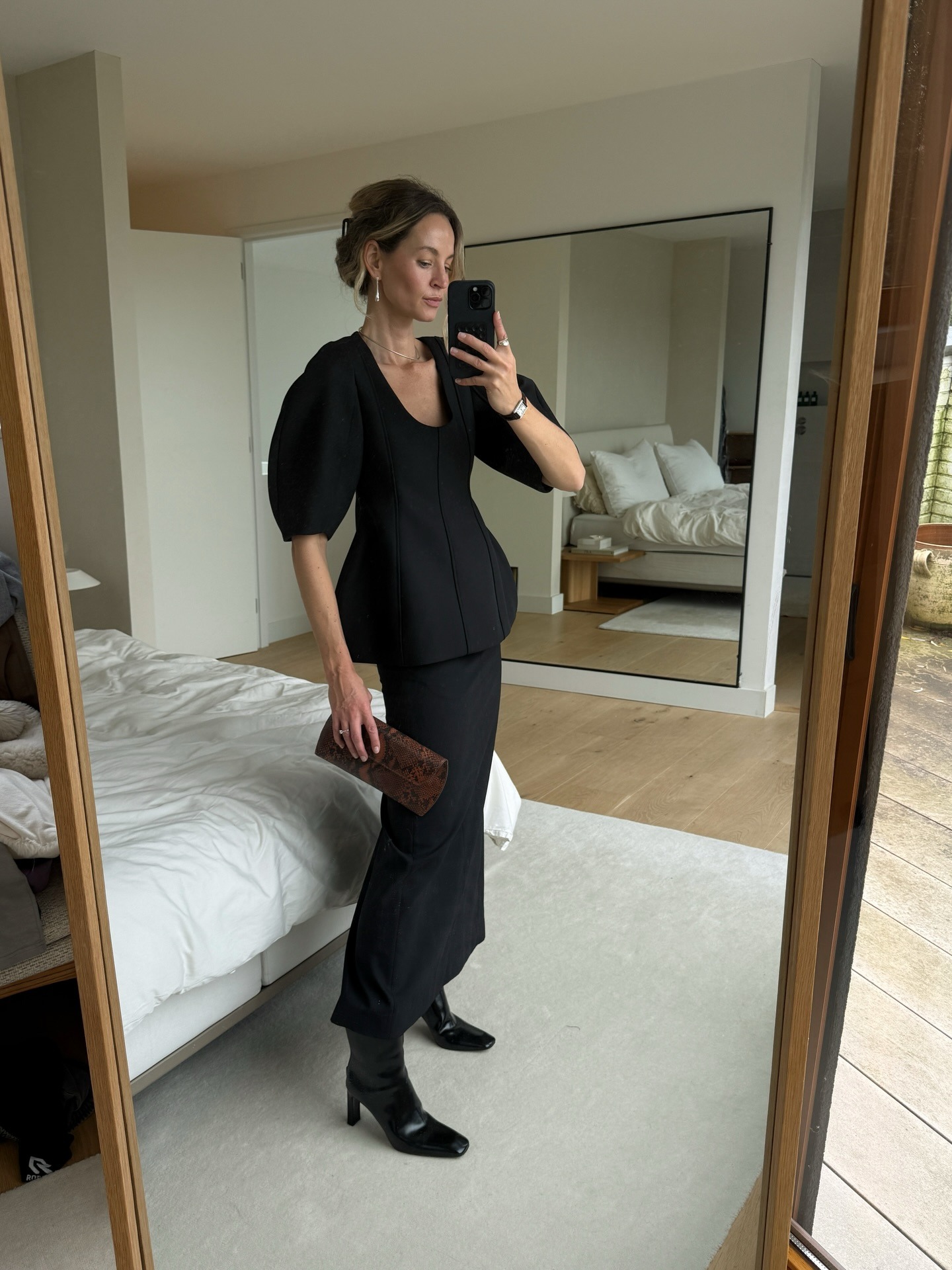 @anoukyve wearing a skirt outfit idea for 2026, including a sculpted black top and matching column skirt.