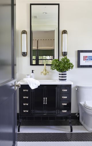 white bathroom with black vanity unit by BHDM