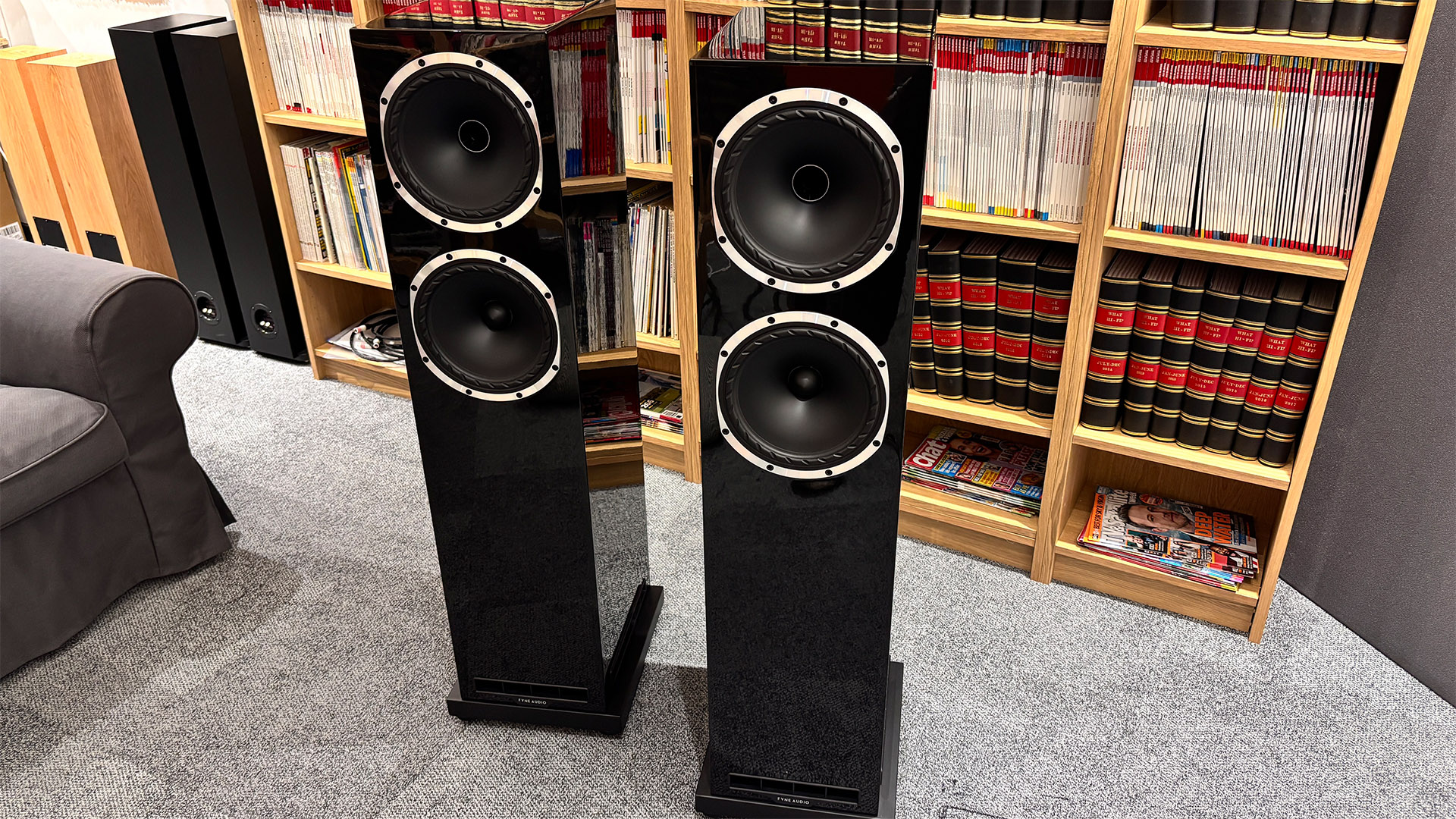 Fyne Audio F502S floorstanding speakers on grey carpet in front of bookcase