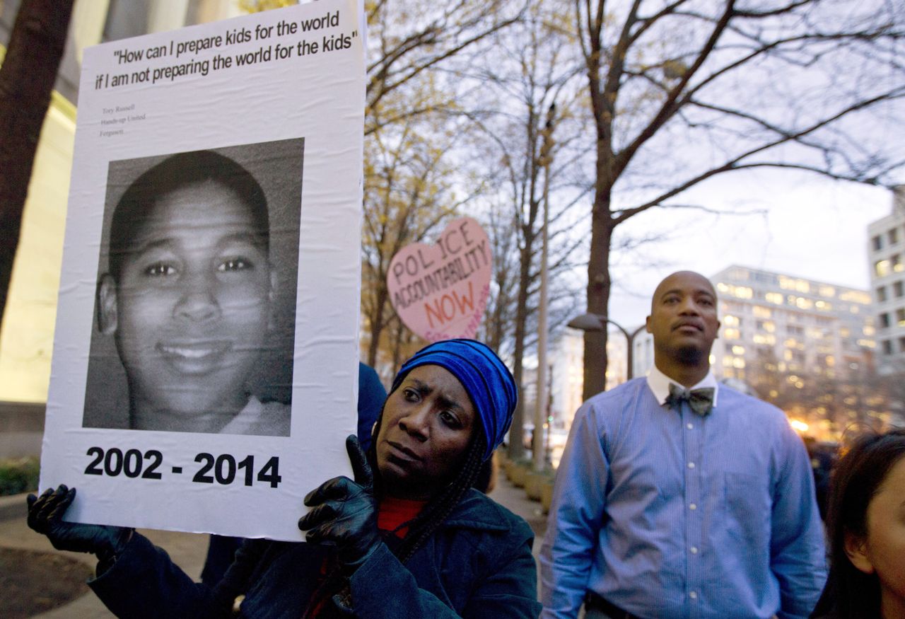 A protester holds up a photo of Tamir Rice.