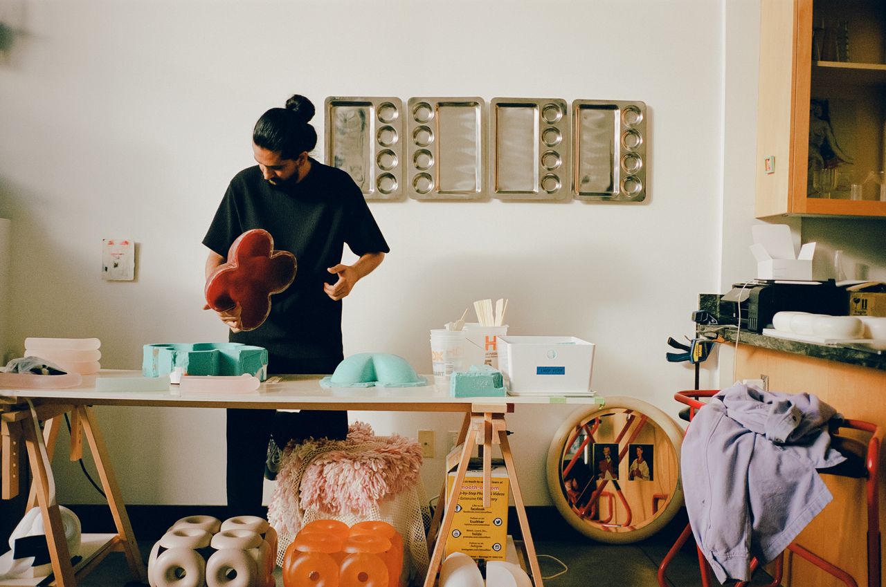 Two young artisans at work in their creations-filled, naturally lit studio.