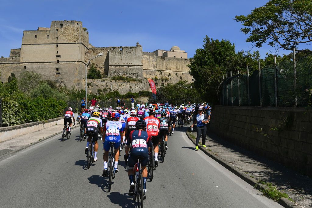 NAPOLI ITALY MAY 14 A general view of the peloton competing next to the Castel dellOvo at Napoli City Seaside during the 105th Giro dItalia 2022 Stage 8 a 153km stage from Napoli to Napoli Giro WorldTour on May 14 2022 in Napoli Italy Photo by Tim de WaeleGetty Images