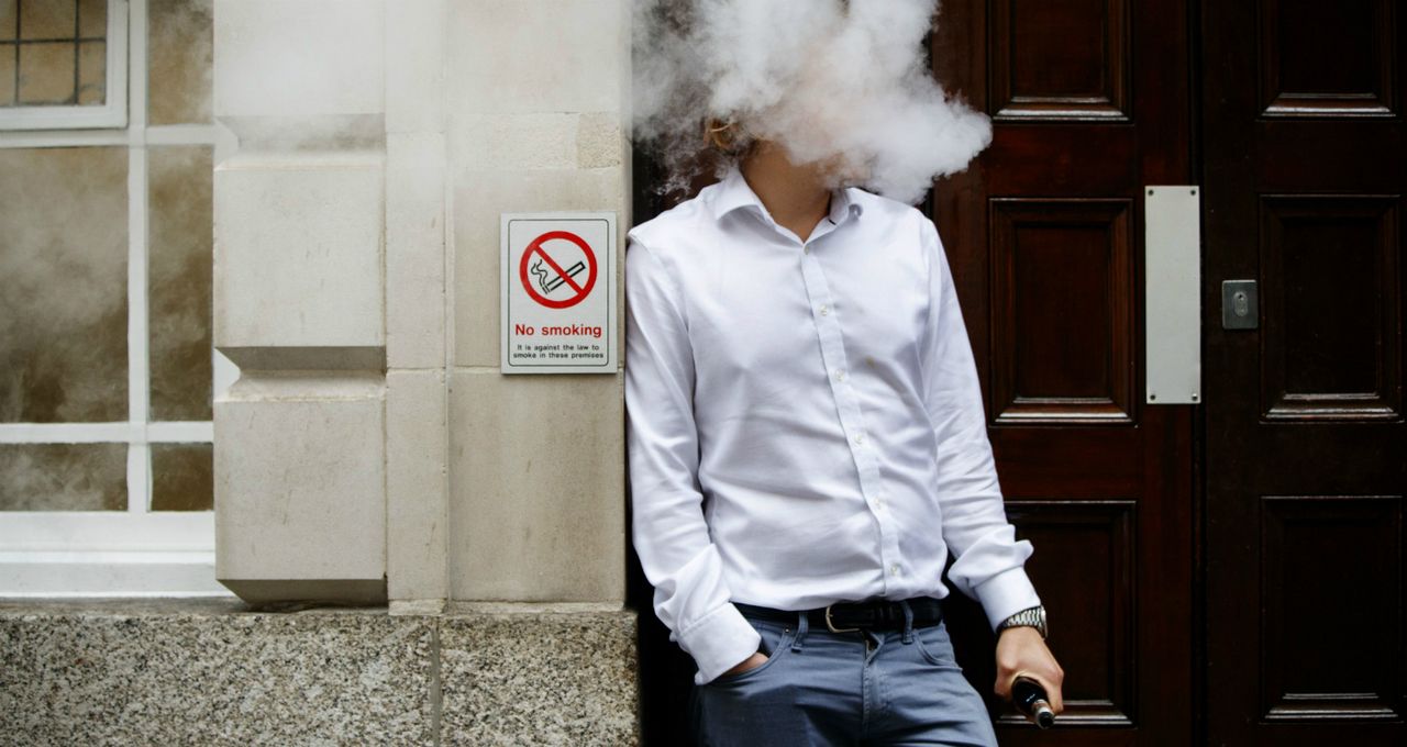 A smoker is engulfed by vapours during lunch time in central London 