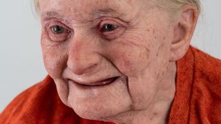 A close-up of a model re-creation of an elderly woman's face.