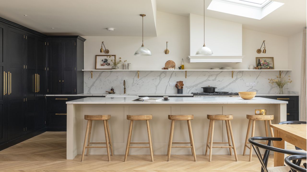 kitchen with black cabinets, white island with wooden bar stools, white shelf and white and grey splashback 