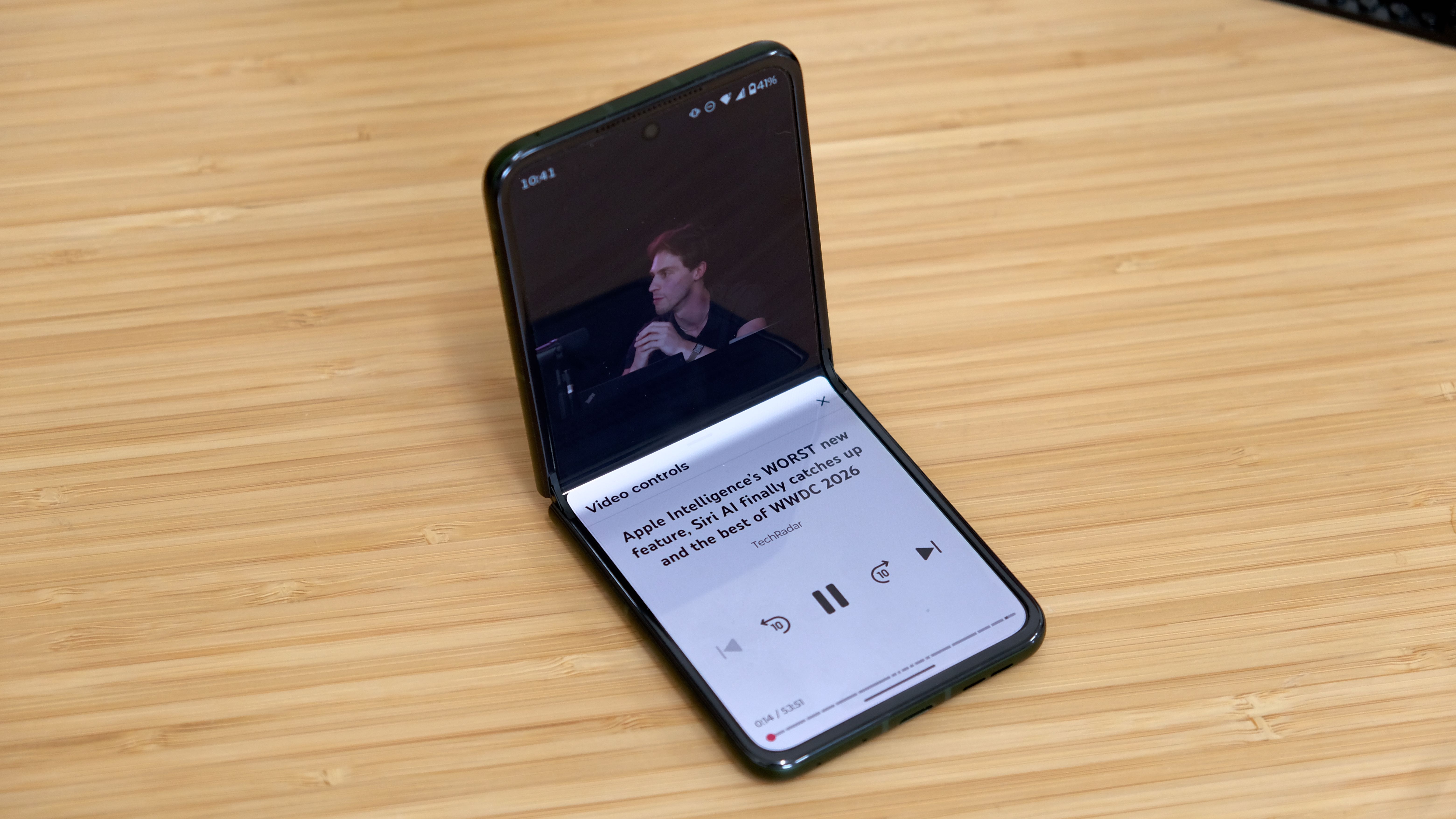 The Motorola Razr Plus 2026 in the hand and on a wooden table