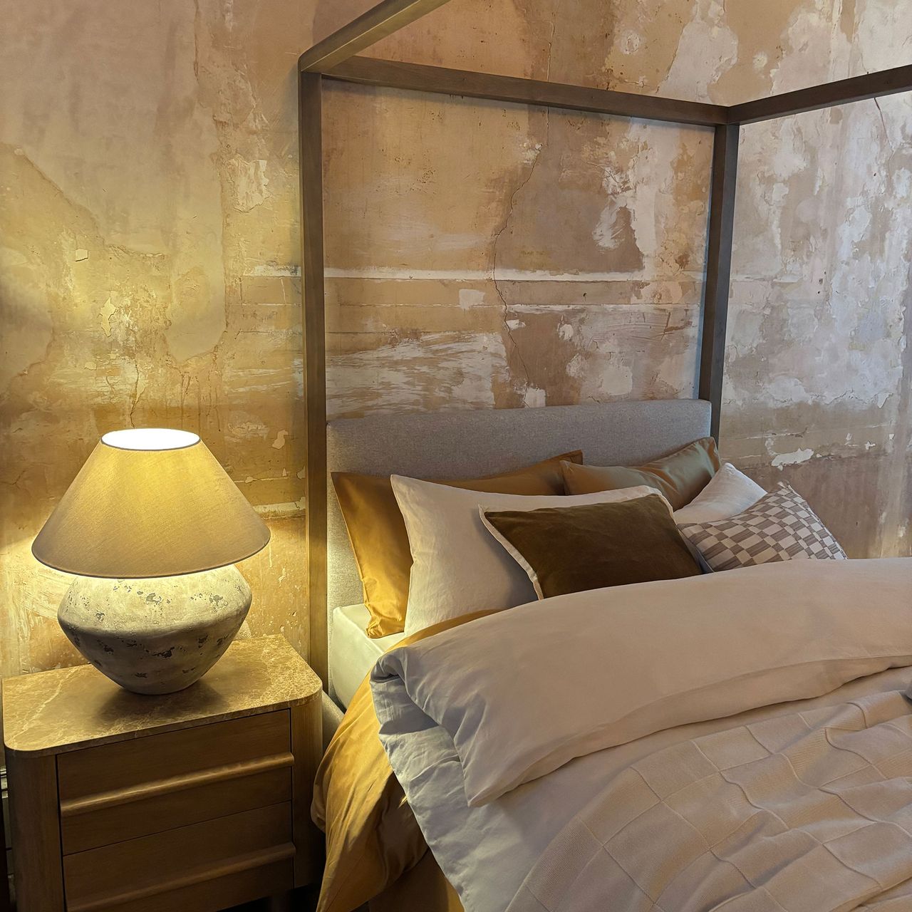 Next homeware bed with neutral coloured cushions and concrete lamp