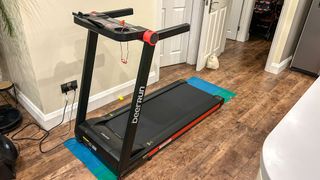 DeerRun A1 Pro treadmill in a person's home showing the handlebars and control panel