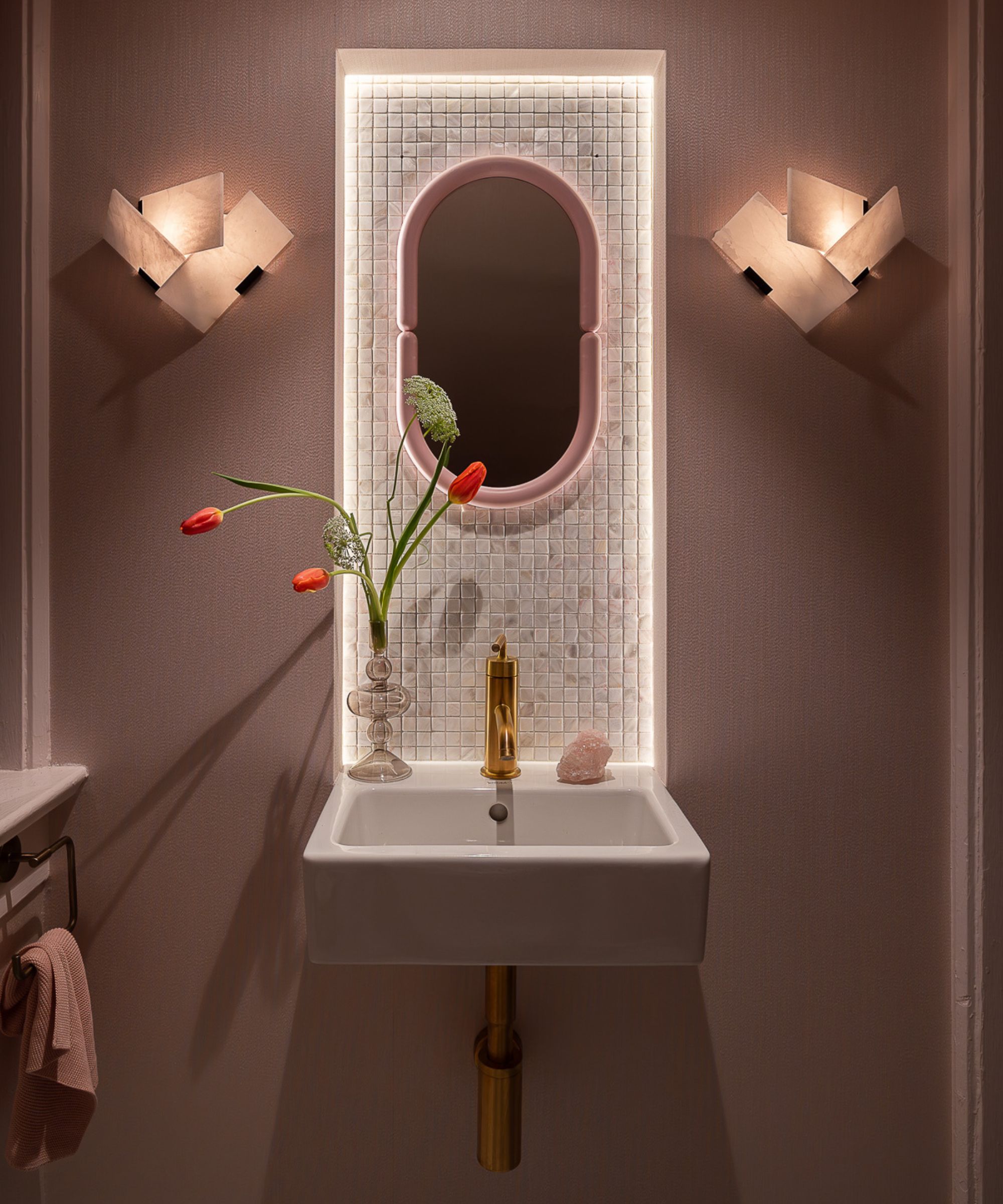 small pale pink modern powder bathroom in a historic home with sculptural wall sconces