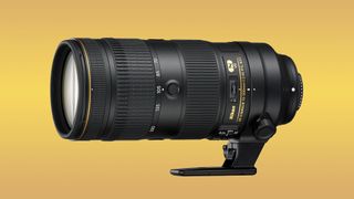 Image shows the Nikkor AF-S FX 70-200mm f/2.8 FL-ED VR telezoom lens against a yellow background.
