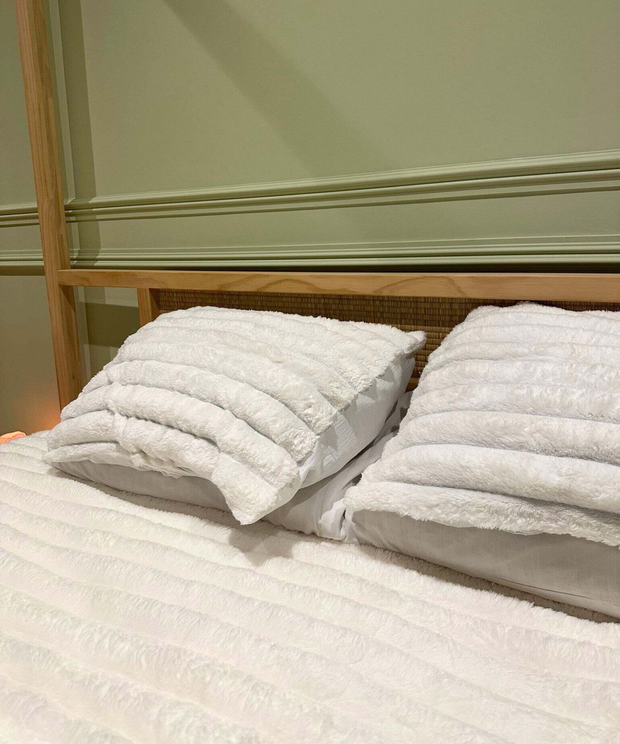 White Bedsure 2-in-1 comforter on a wooden four-poster, Japanese-style bed. The wall behind is pale green and panelled.