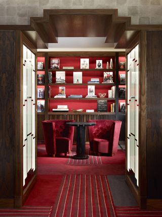 Featuring Transatlantic Chairs, a carpet, and a large wooden bookcase in the Map Room