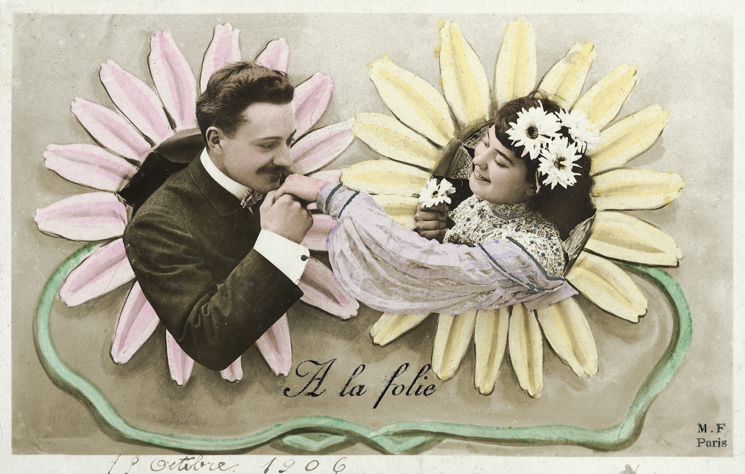 A postcard of a Victorian man and woman, framed by illustrated flower petals. The man is kissing the woman's hand