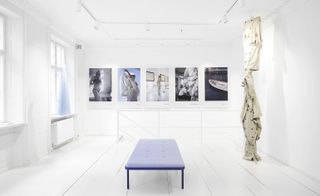 Interior of Label Viu boutique in Copenhagen, including photographic art on the walls and a trench coat sculpture