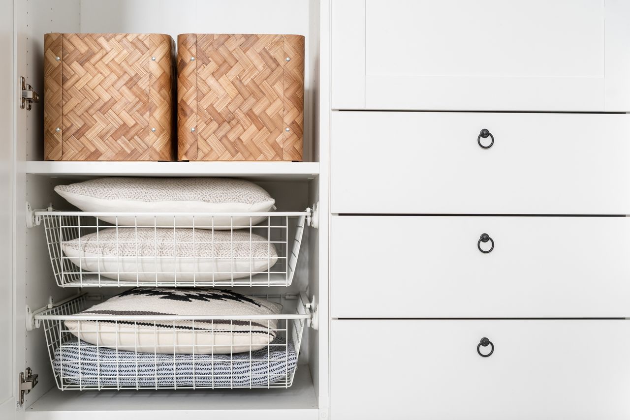 A closet with wicker storage baskets and wire baskets