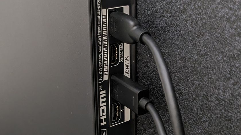 A row of HDMI ports on the back of a TV, with two cables attached in specific ports, with an empty port labelled 'HDMI ARC'