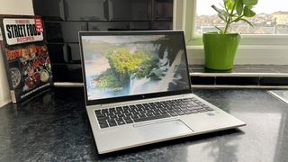 The HP EliteBook 840 G7 as seen from the front, with a cookbook and window in the background