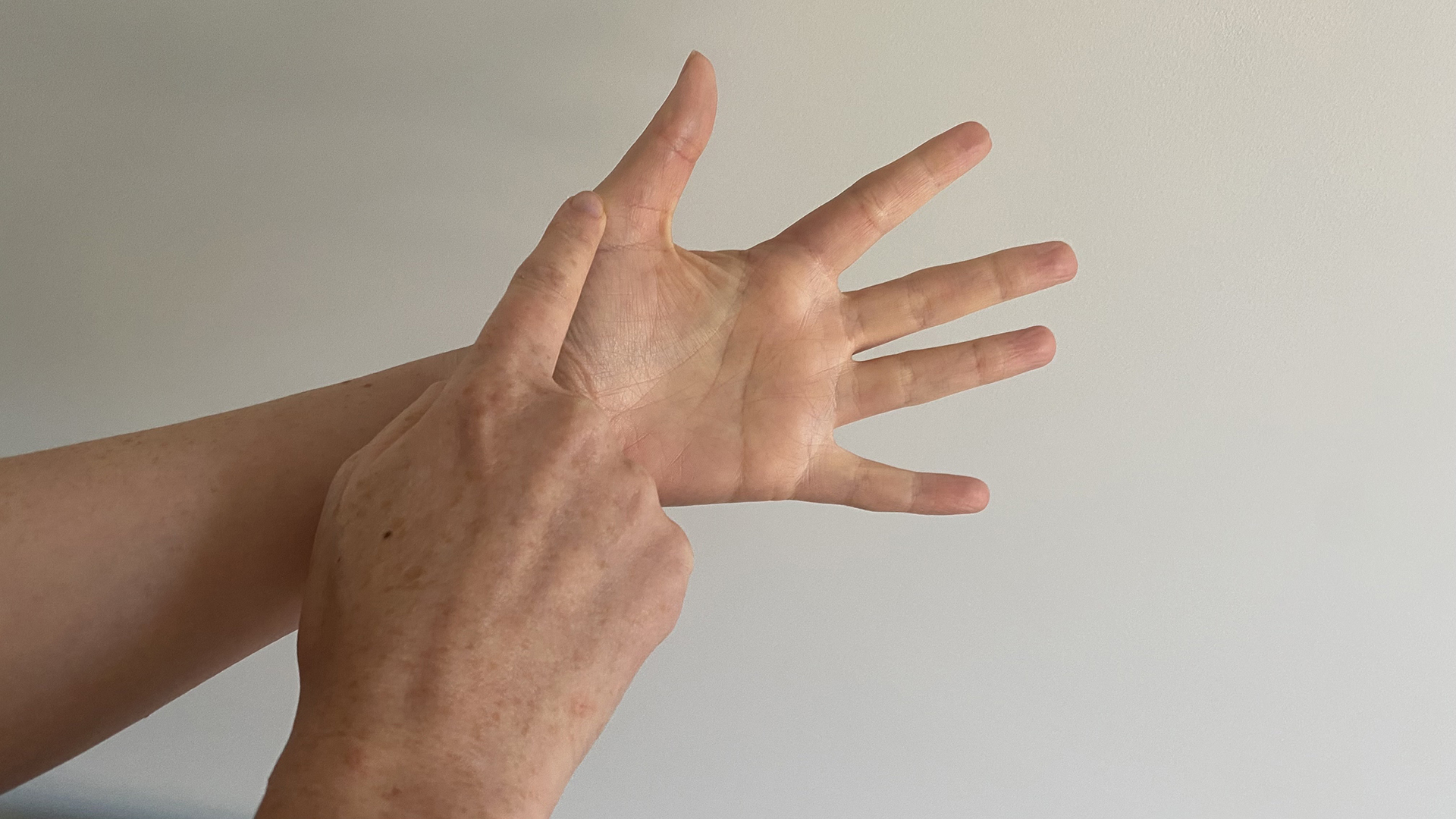 A close up of two hands starting the finger breathing relaxation for technique, with the trace finger racing at the base of the thumb
