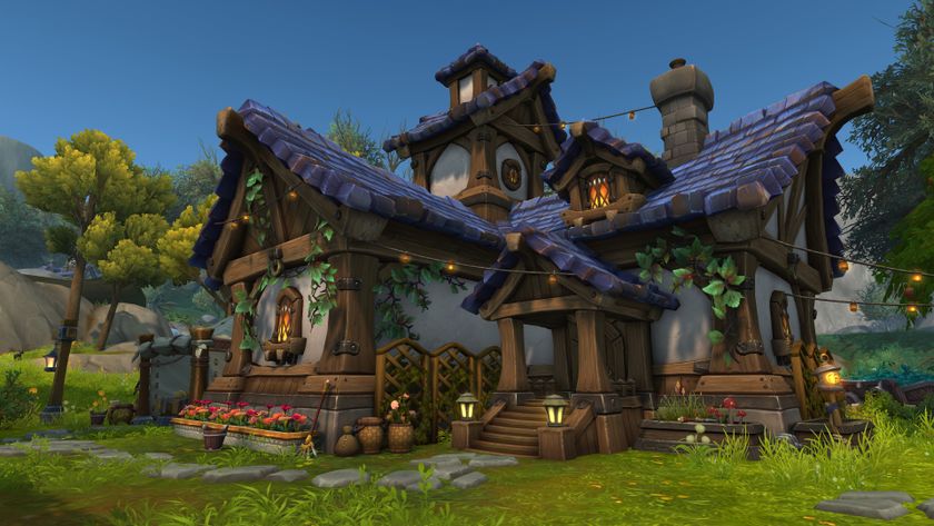 An in-development screenshot of World of Warcraft&#039;s player housing, which is coming in the Midnight expansion. A blue-roofed cottage covered in vines and lights sits in a valley.