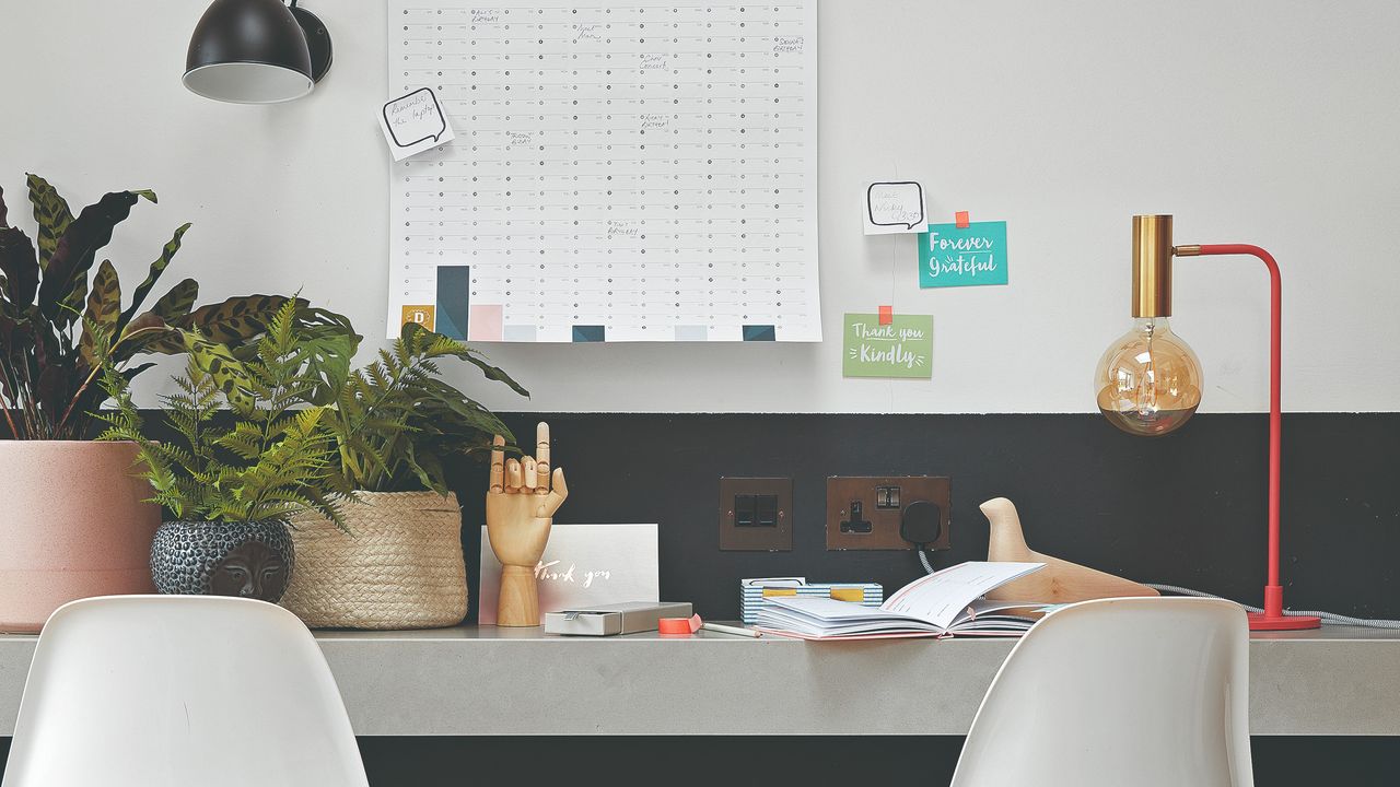 A home office with a desk and chairs and houseplants