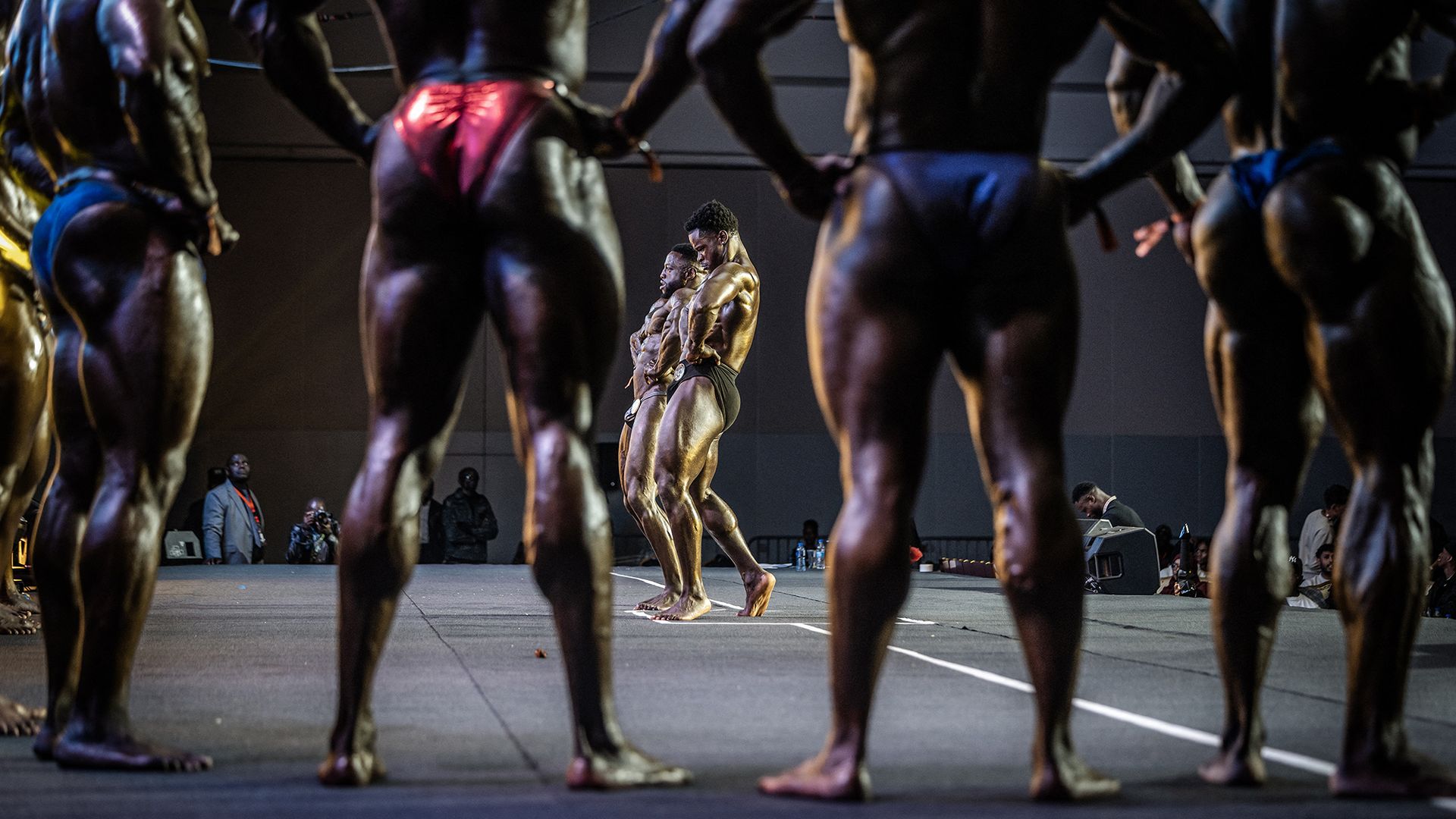 Competitors in the Men's Open Bodybuilding category strike a pose during the 2026 Body Fuel International Fitness Championship in Nairobi, Kenya