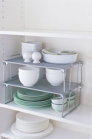 kitchen cabinet shelves within in a drawer holding bowls and mugs