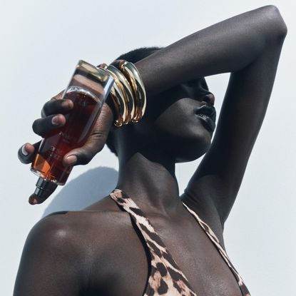 model holding up zara golden decade perfume bottle over her fave 