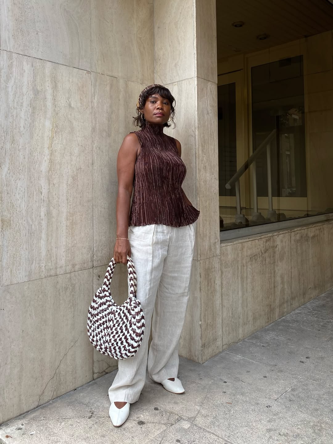 Frann Fyne wears white linen trousers and brown top