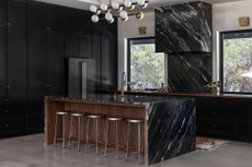 An all black kitchen with a muted flooring