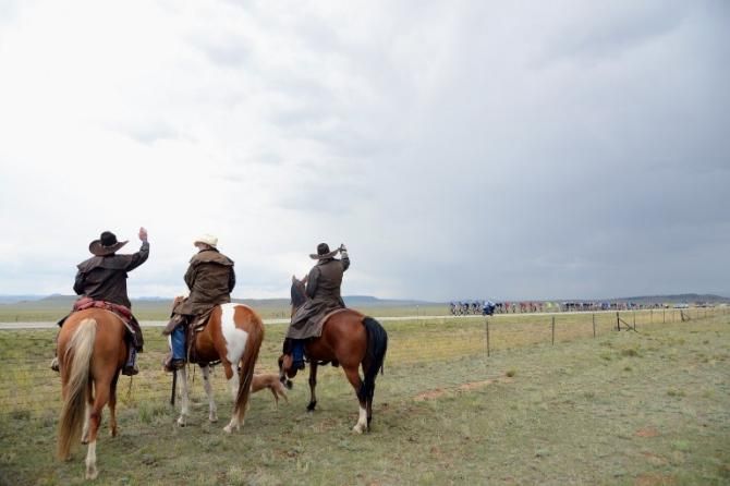 The USA Pro Challenge peloton gets encouragement from some cowboys.