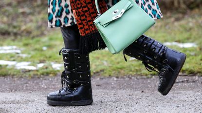 mint green bag by Hermes and black vintage snow boots by Valentino as a detail of influencer and TV host Cathy Hummels during a street style shooting on January 24, 2021 in Munich, Germany