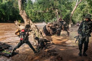 Soldiers and an elephant by a river in Myanmar