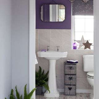 bathroom with white sink mirror on purple wall