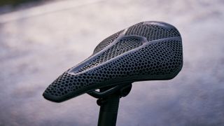 A close up of a black saddle with a mesh upper