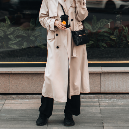 Woman walking around the city with a cup of coffee with crossbody bag 