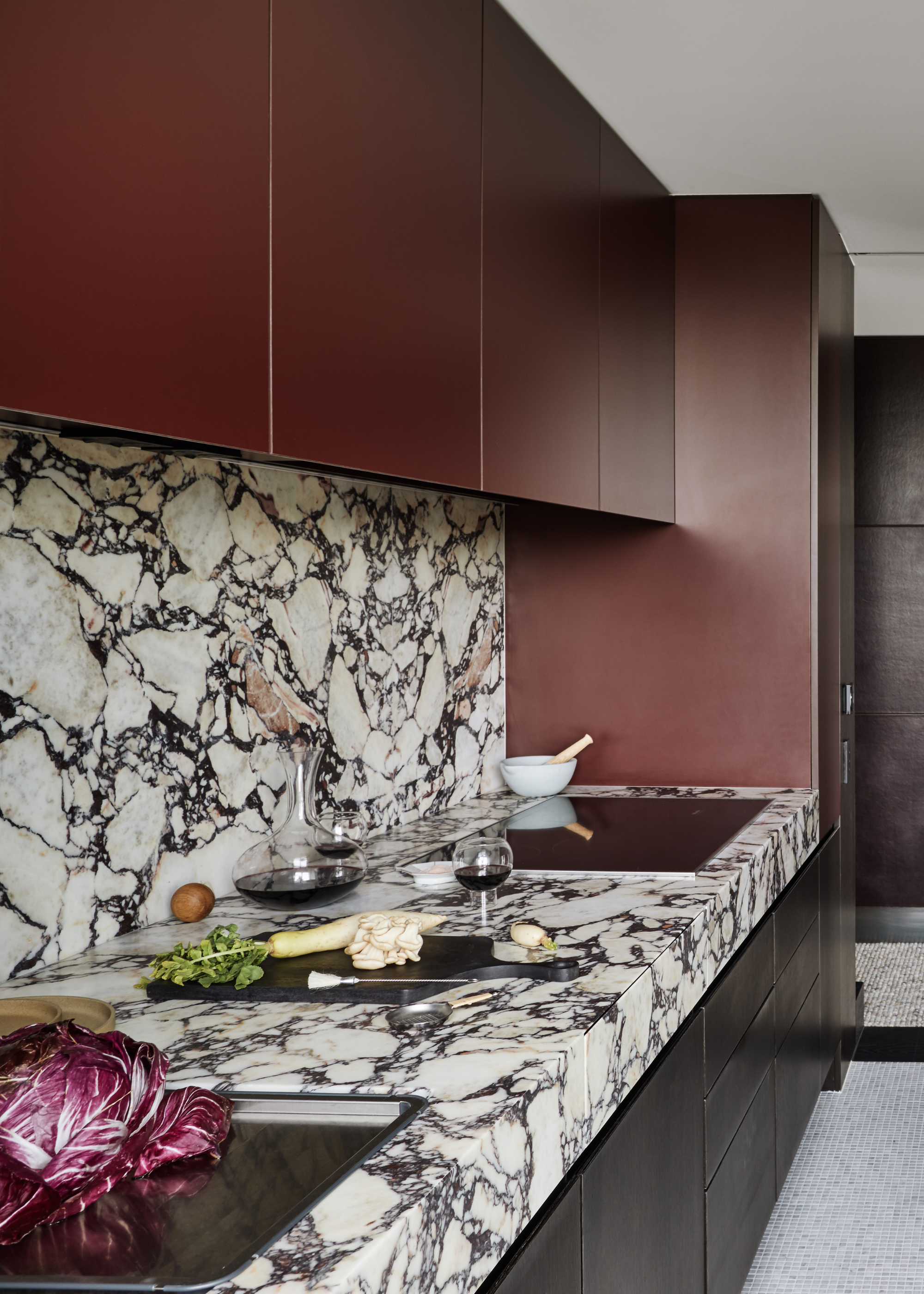 modern kitchen with calcatta viola counters and backsplash, and dark, burgundy cabinets