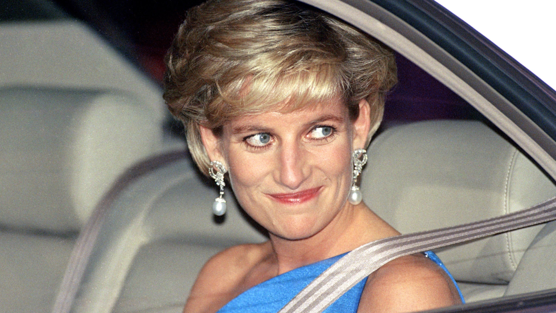 Princess Diana in a car wearing a blue gown and pearl drop earrings