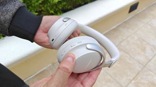 Our reviewer testing the Bose QC Ultra's volume strip control