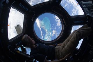 NASA astronaut Shannon Walker looks at Earth from the International Space Station in November 2010.