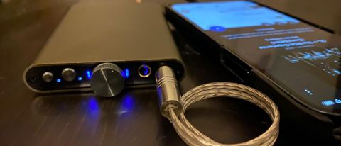 iFi hip-dac 3 next to a smartphone, on black table