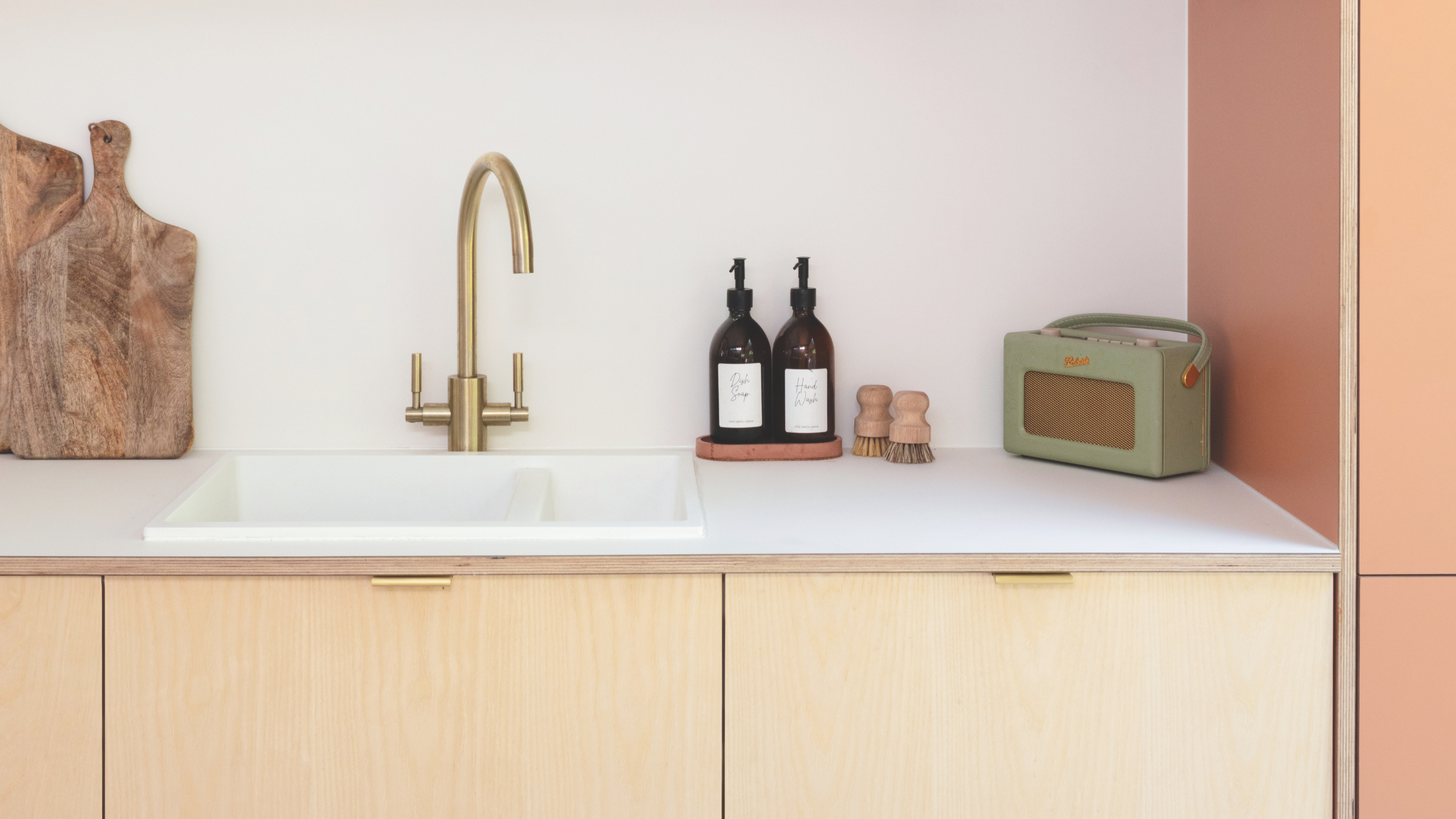 Kitchen sink in pink and wood kitchen.