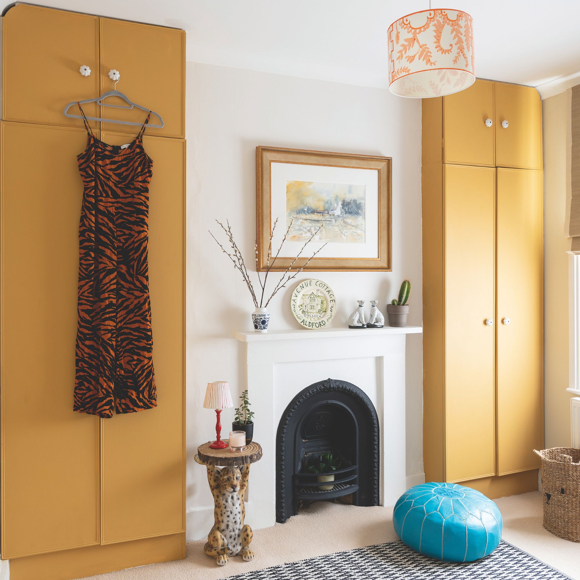 Dressing room with a white fireplace, with yellow built-in wardrobes on either side of it