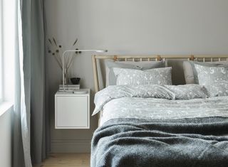 Bedroom with wooden Ikea bed and floating side table